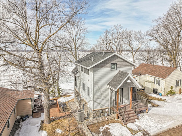 view of front of property featuring a shingled roof, central AC, and a porch