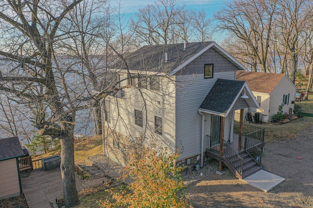 view of front of home featuring a shingled roof and central AC