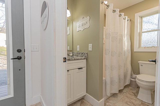 bathroom with toilet, shower / bath combination with curtain, vanity, and baseboards