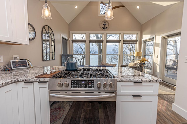 kitchen with pendant lighting, light stone countertops, gas range, and white cabinetry