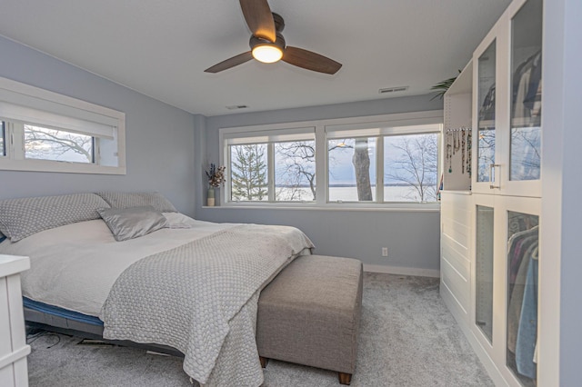 bedroom featuring multiple windows, visible vents, and light colored carpet