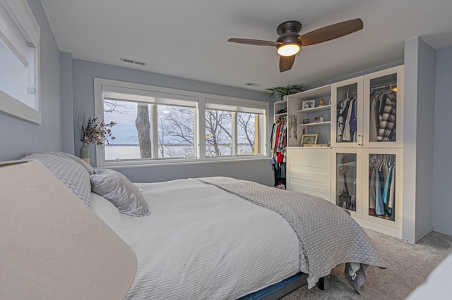 bedroom with carpet, visible vents, and a ceiling fan