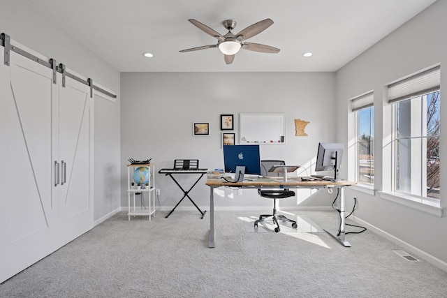 office area with visible vents, a barn door, carpet flooring, baseboards, and ceiling fan