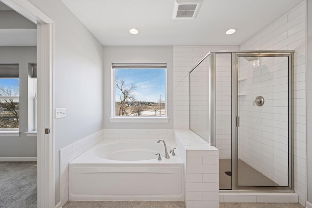 bathroom featuring a bath, visible vents, a wealth of natural light, and a stall shower