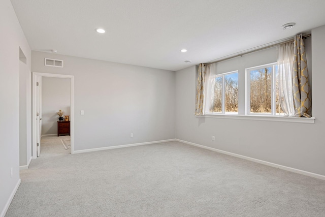 spare room featuring visible vents, recessed lighting, light colored carpet, and baseboards