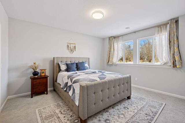 bedroom featuring light colored carpet and baseboards