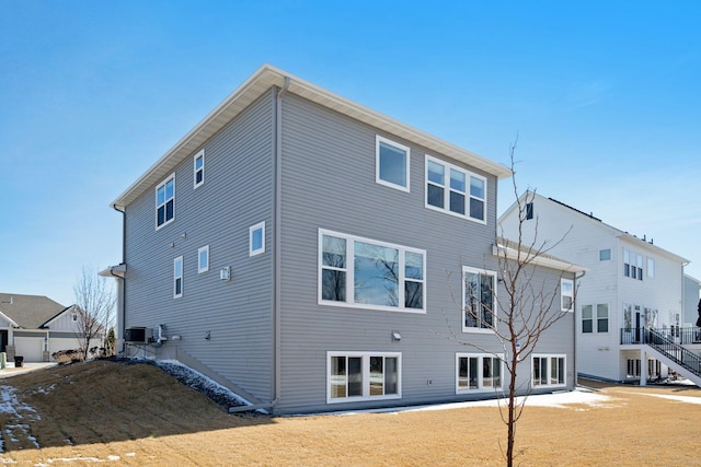 back of property featuring a yard and central AC