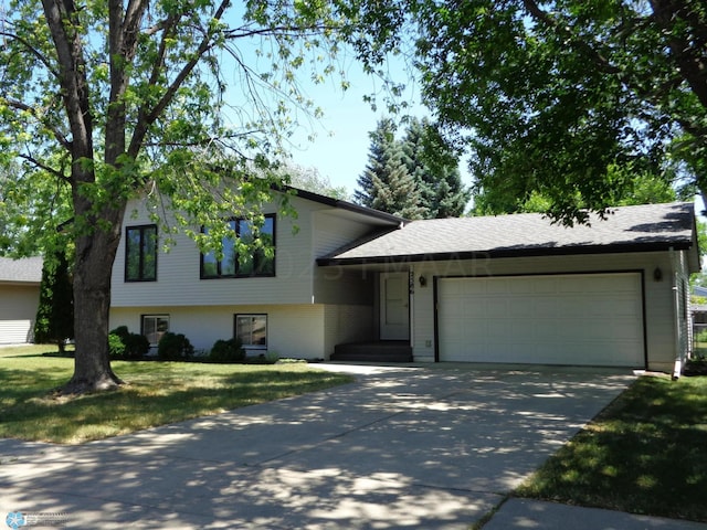 split level home featuring an attached garage, a front lawn, and concrete driveway