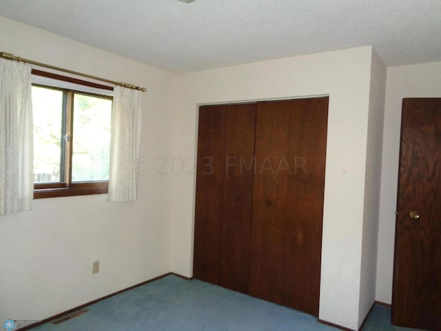 unfurnished bedroom with carpet floors, a closet, and baseboards