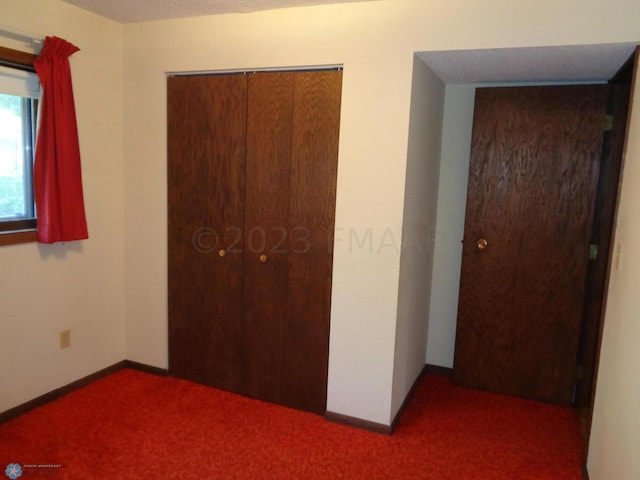 unfurnished bedroom featuring carpet, a closet, and baseboards