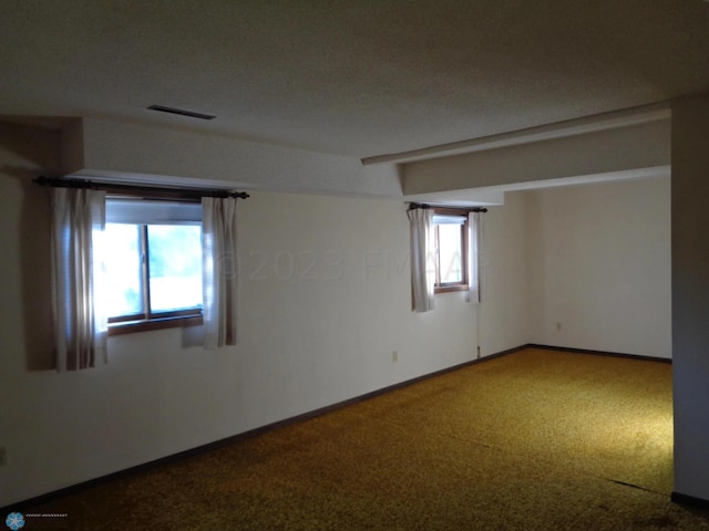 unfurnished room with carpet flooring, visible vents, and baseboards