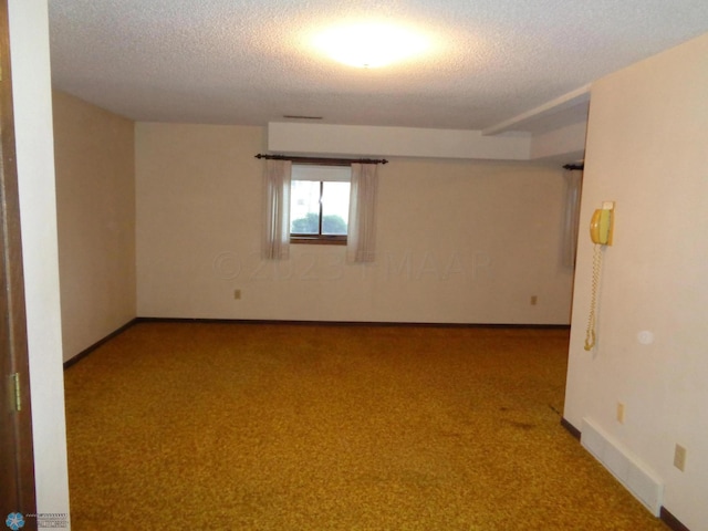 unfurnished room with light carpet, a textured ceiling, and baseboards