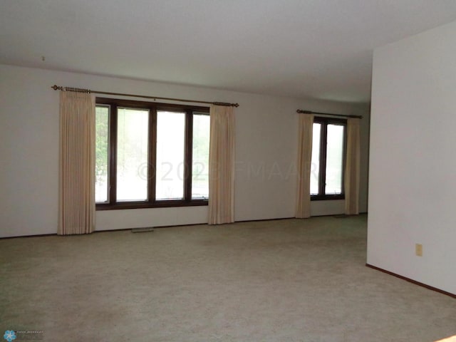 empty room with light colored carpet and visible vents