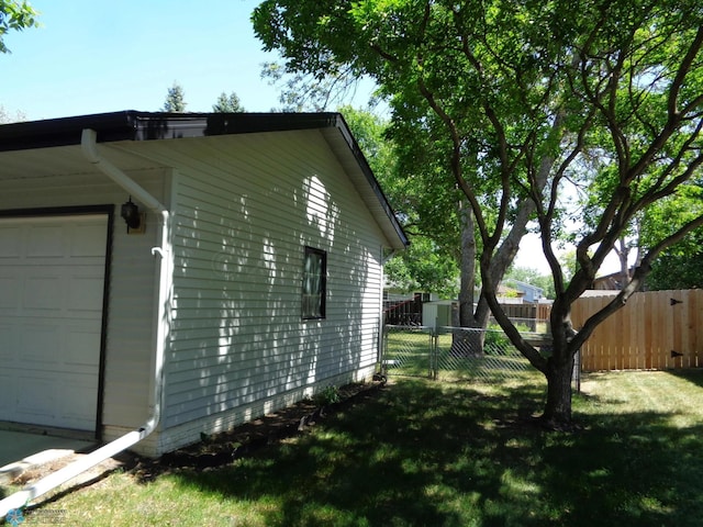 view of property exterior featuring a garage, fence, and a yard