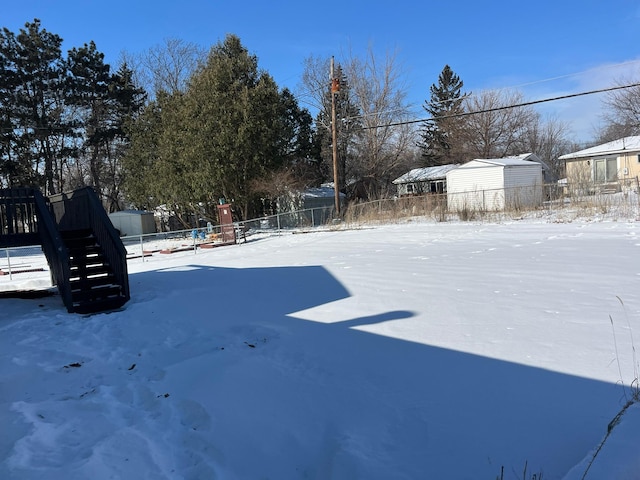 snowy yard featuring fence