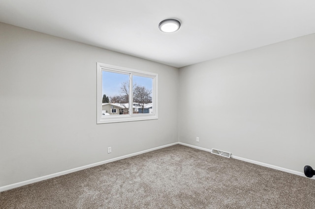 carpeted spare room with visible vents and baseboards