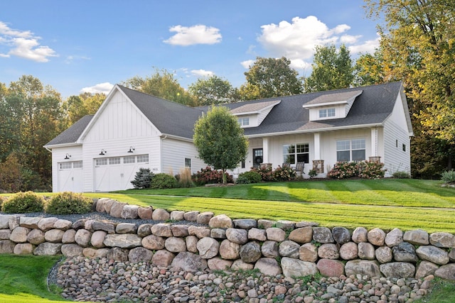 modern inspired farmhouse with a garage, roof with shingles, board and batten siding, and a front lawn