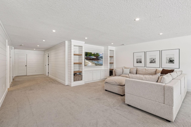 living area with a textured ceiling, recessed lighting, and light colored carpet