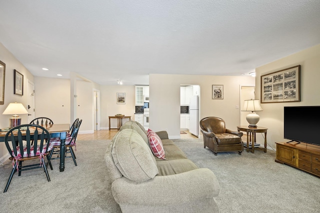 carpeted living room with baseboards, a textured ceiling, and recessed lighting