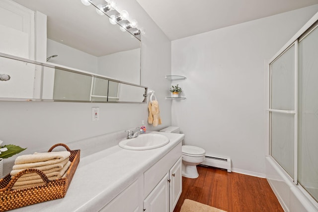 bathroom featuring baseboards, toilet, wood finished floors, baseboard heating, and vanity