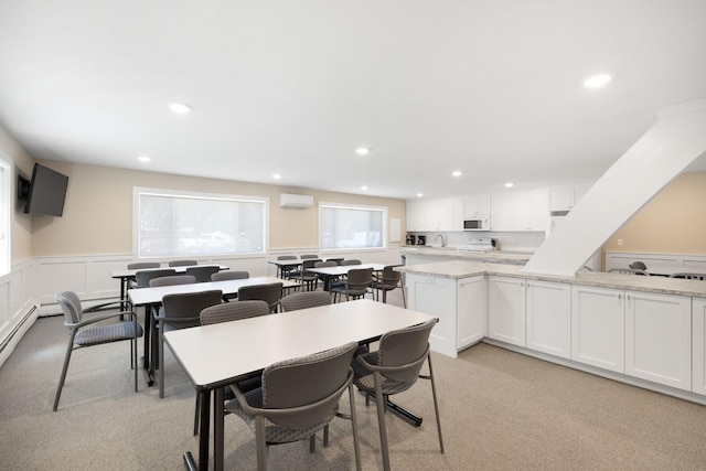 dining area with a wainscoted wall, recessed lighting, an AC wall unit, and light colored carpet