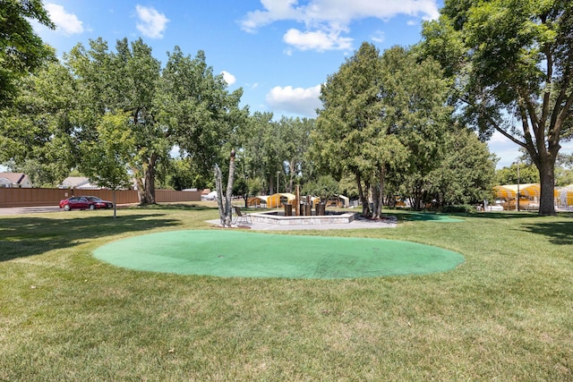view of property's community with a yard and fence