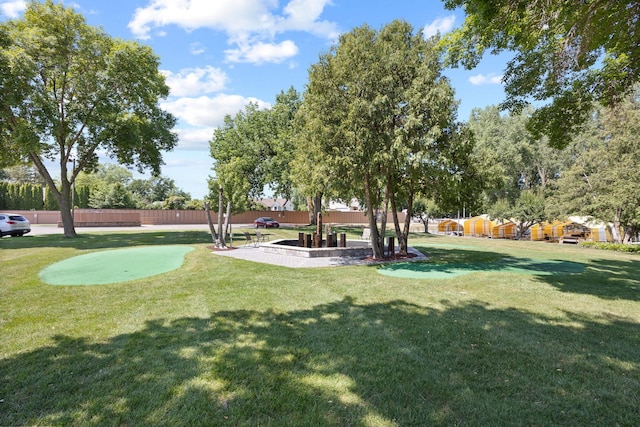 view of home's community featuring a lawn and fence