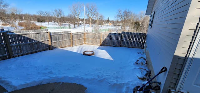 yard layered in snow with a fenced backyard