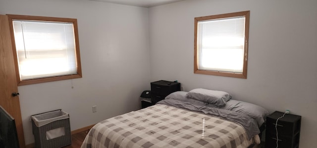 bedroom featuring multiple windows and wood finished floors