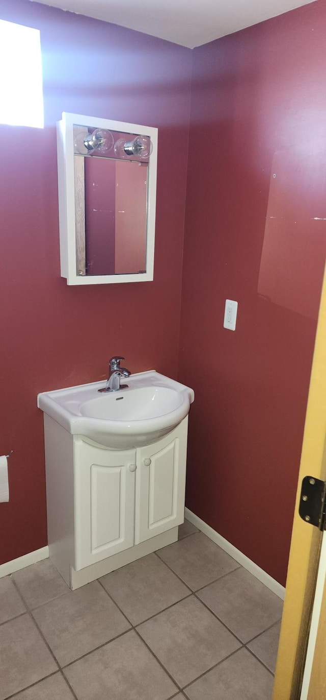 bathroom with tile patterned flooring, baseboards, and vanity