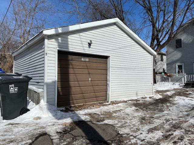 snow covered garage with a garage