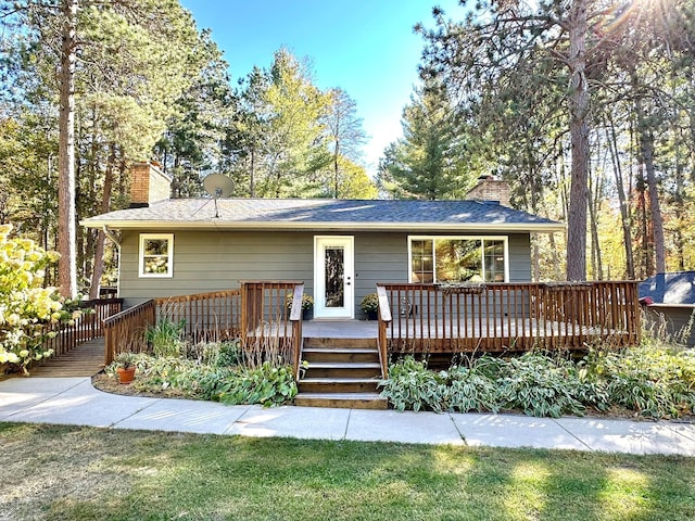 view of front of home with a chimney and a deck