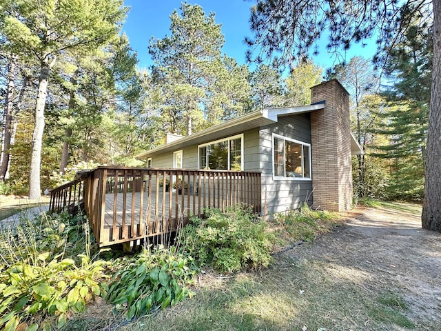 view of side of property with a deck and a chimney