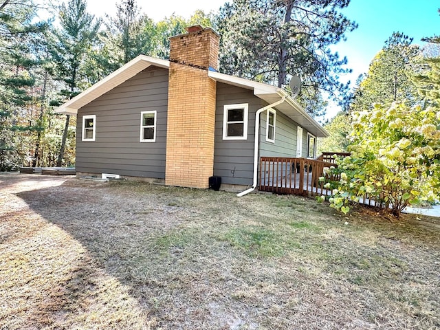 view of side of home with a chimney and a deck