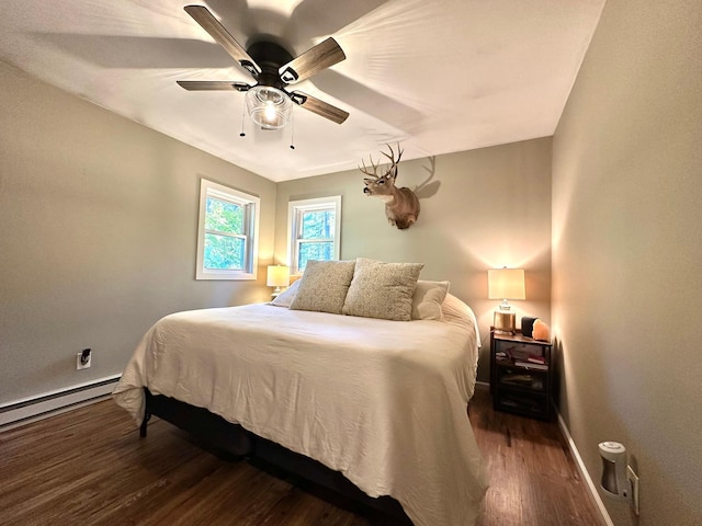 bedroom with baseboards, a baseboard heating unit, ceiling fan, and dark wood-type flooring