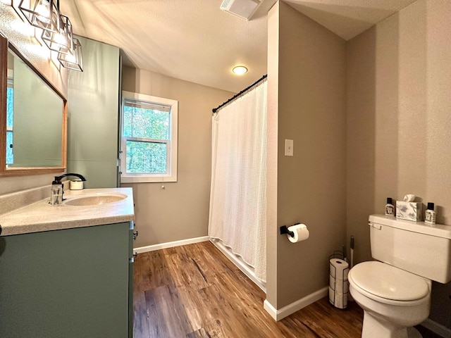 full bathroom featuring visible vents, toilet, vanity, wood finished floors, and baseboards