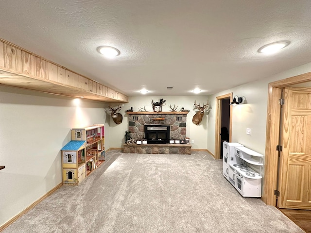 interior space with carpet floors, baseboards, a stone fireplace, and a textured ceiling