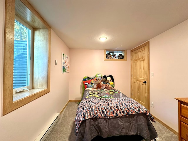 carpeted bedroom with baseboard heating and baseboards