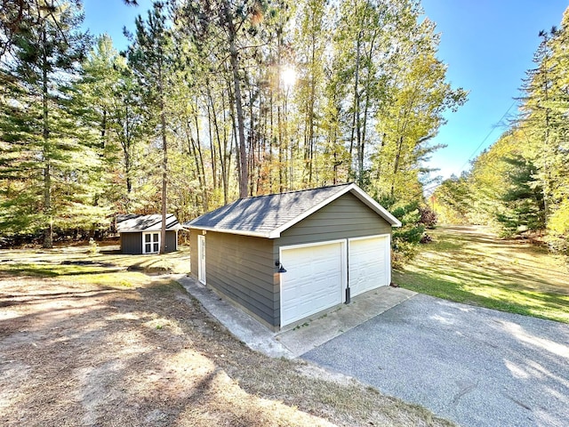 detached garage featuring a shed