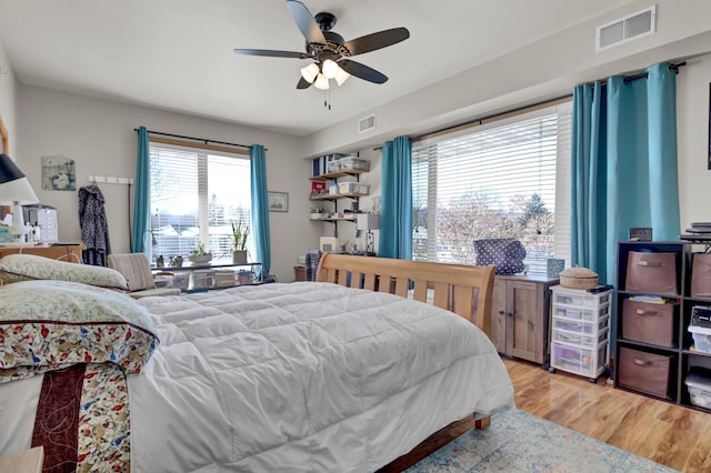 bedroom featuring ceiling fan, visible vents, and wood finished floors