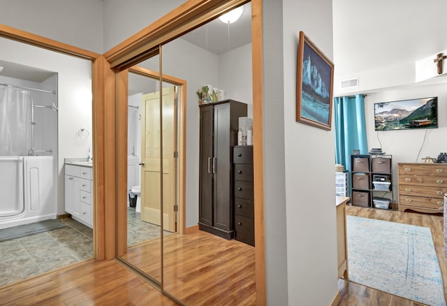 hall featuring visible vents and wood finished floors