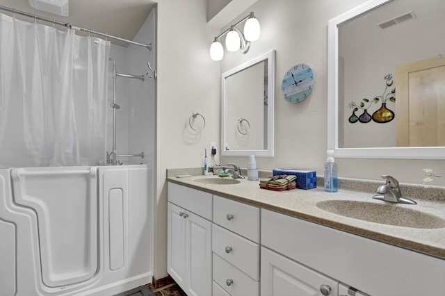 bathroom with a shower with curtain, visible vents, a sink, and double vanity