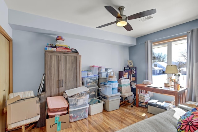 bedroom featuring a ceiling fan, visible vents, and wood finished floors