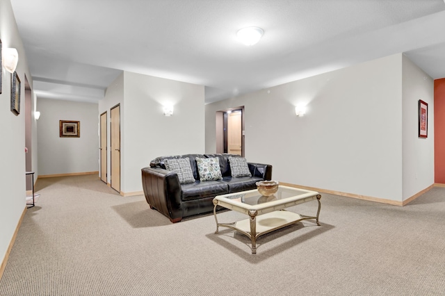 living area featuring light carpet and baseboards