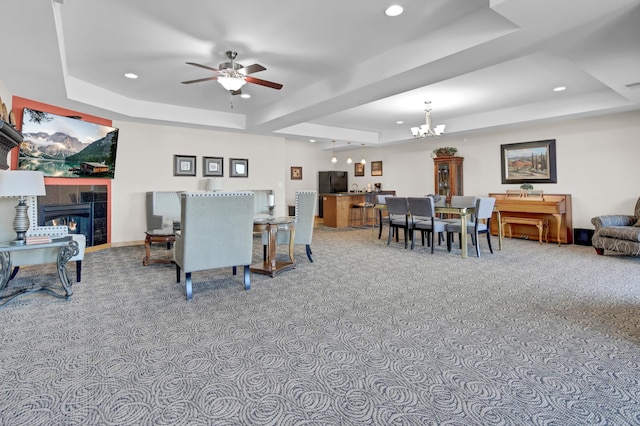 living room featuring recessed lighting, a tray ceiling, and a tile fireplace