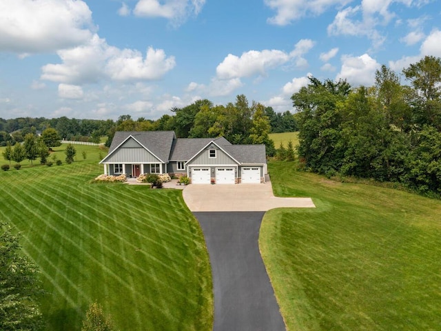 view of front of home featuring a garage, driveway, a front lawn, and board and batten siding