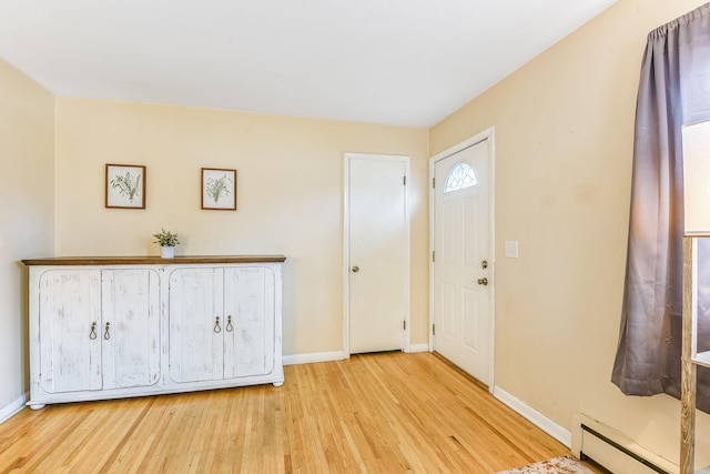 foyer entrance featuring baseboards, baseboard heating, and wood finished floors