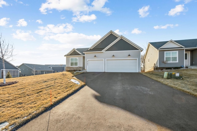 view of front of home featuring aphalt driveway, an attached garage, and a front yard