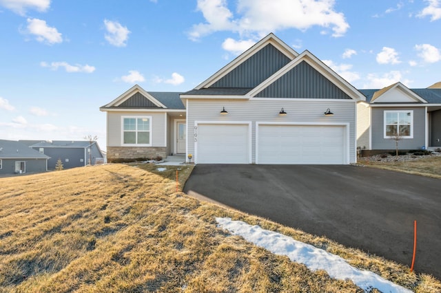 view of front of home featuring driveway, a front lawn, board and batten siding, and an attached garage