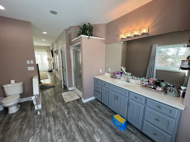 full bathroom with a stall shower, plenty of natural light, wood finished floors, and vanity